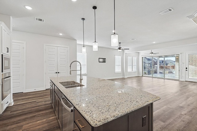 kitchen with sink, hanging light fixtures, dark brown cabinets, stainless steel appliances, and white cabinets