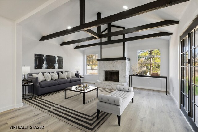 unfurnished living room featuring a stone fireplace, lofted ceiling with beams, and light hardwood / wood-style flooring