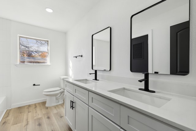 full bathroom featuring vanity, wood-type flooring,  shower combination, and toilet