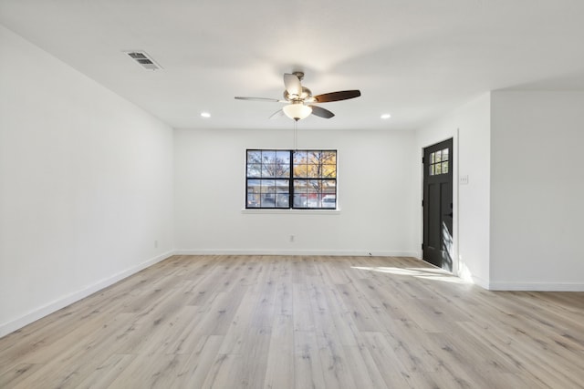 empty room with baseboards, light wood-style flooring, visible vents, and a wealth of natural light