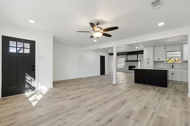 unfurnished living room featuring light wood-style floors, a fireplace, visible vents, and recessed lighting