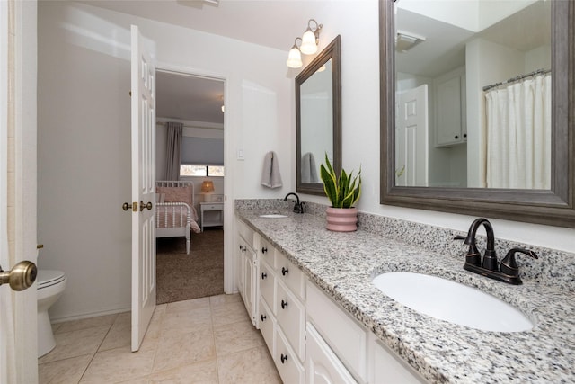 bathroom featuring toilet, tile patterned flooring, and vanity