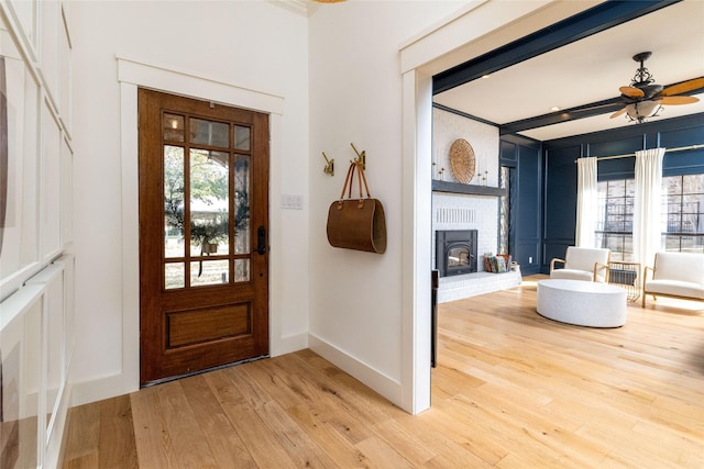 entrance foyer with ceiling fan, a healthy amount of sunlight, beam ceiling, and hardwood / wood-style flooring