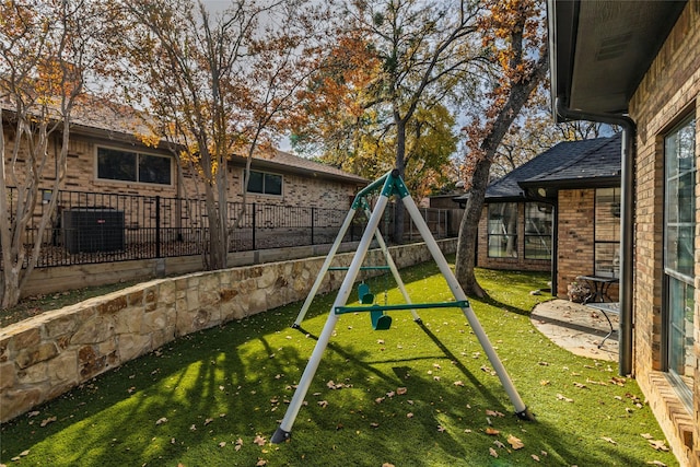 view of jungle gym featuring a yard and central AC unit