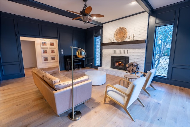 living room featuring beamed ceiling, crown molding, and light hardwood / wood-style floors