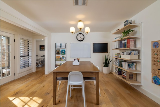 office featuring an inviting chandelier and light hardwood / wood-style floors