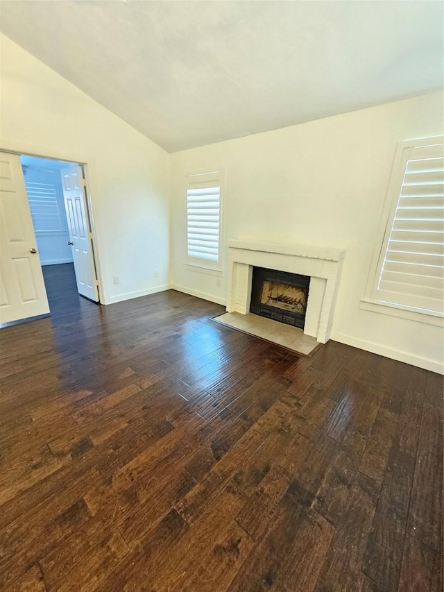 unfurnished living room featuring lofted ceiling, dark hardwood / wood-style floors, and a high end fireplace