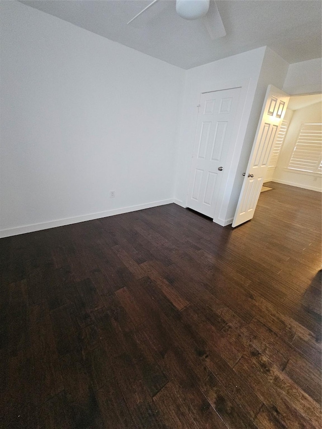 spare room with dark wood-type flooring and ceiling fan