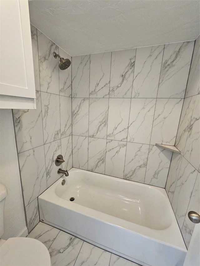 bathroom featuring toilet and tiled shower / bath combo