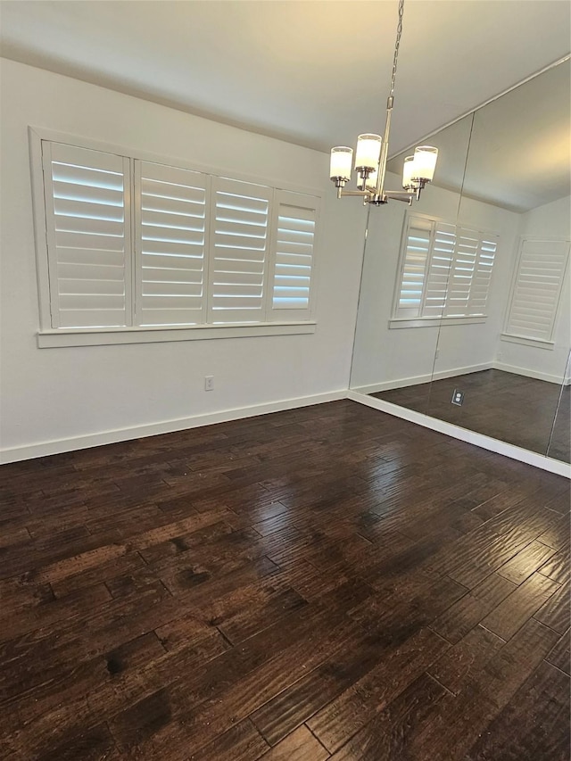 unfurnished dining area with a notable chandelier and dark hardwood / wood-style flooring