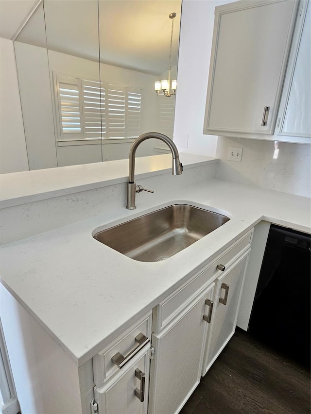 kitchen with dishwasher, sink, white cabinets, and decorative light fixtures