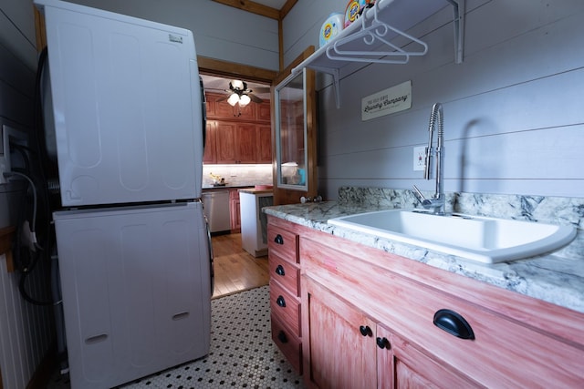 bathroom featuring stacked washer / drying machine, sink, and ceiling fan