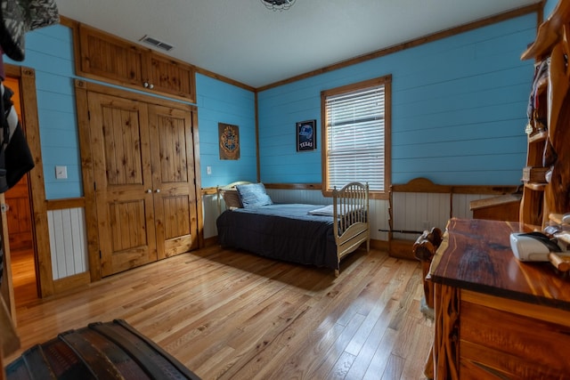 bedroom with crown molding and light hardwood / wood-style flooring