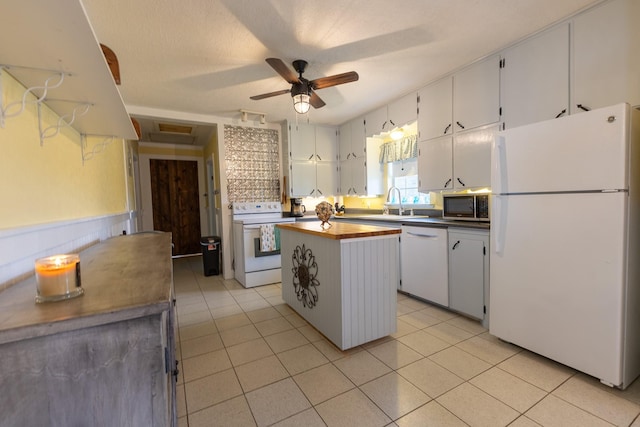 kitchen featuring light tile patterned floors, white appliances, ceiling fan, a center island, and white cabinets