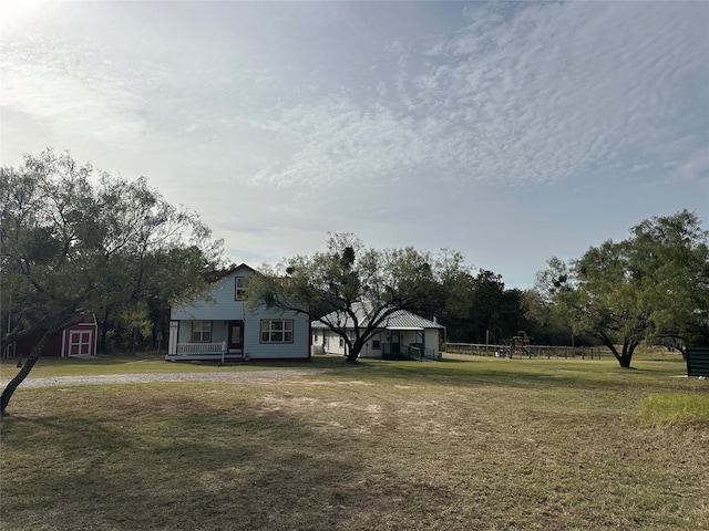 view of yard featuring a storage shed and a porch