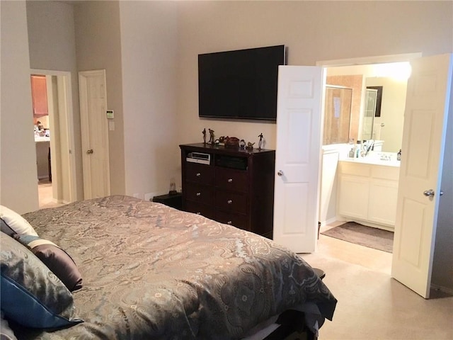 bedroom with ensuite bath and light carpet