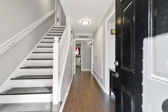 entryway featuring ornamental molding and dark wood-type flooring