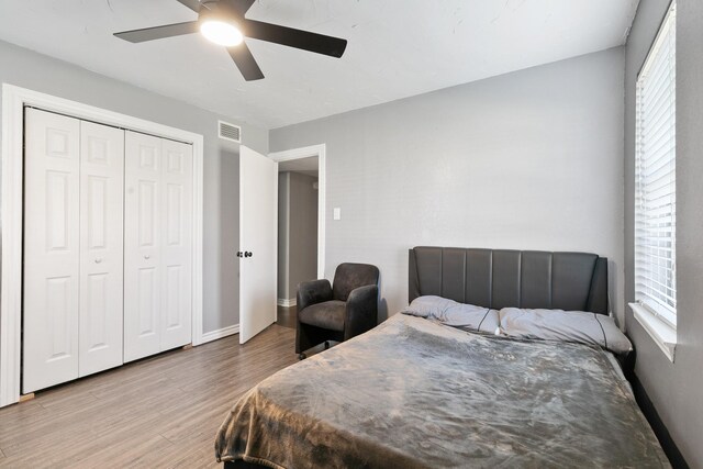 bedroom with hardwood / wood-style floors, ceiling fan, and a closet