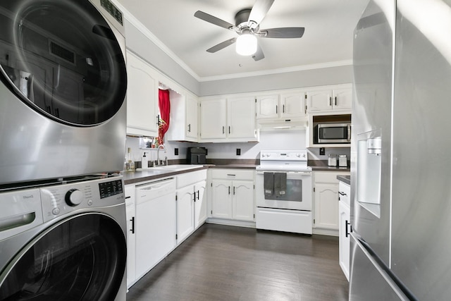 kitchen with appliances with stainless steel finishes, dark hardwood / wood-style flooring, ornamental molding, stacked washer and clothes dryer, and white cabinets