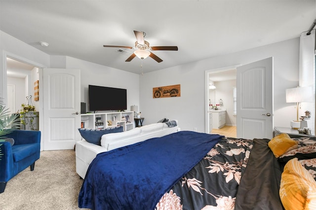 carpeted bedroom with ceiling fan and ensuite bath