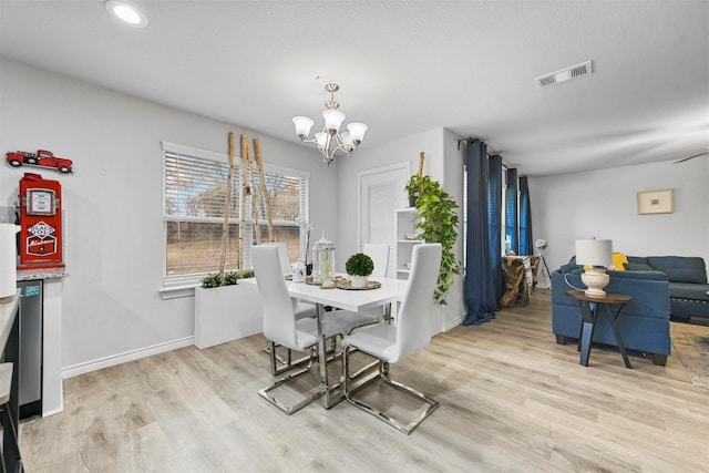 dining space featuring ceiling fan with notable chandelier and light hardwood / wood-style flooring