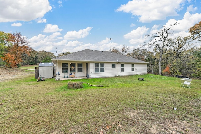 back of property with a lawn and a storage shed