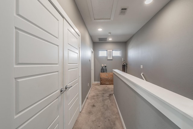 corridor featuring light carpet, baseboards, visible vents, and an upstairs landing