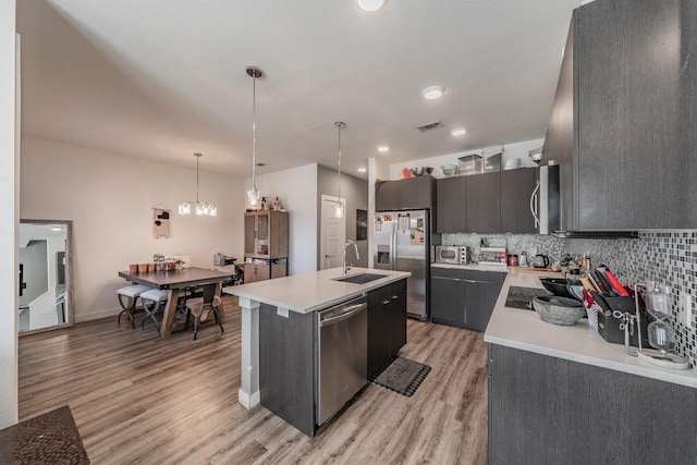 kitchen with stainless steel appliances, light countertops, visible vents, and a sink