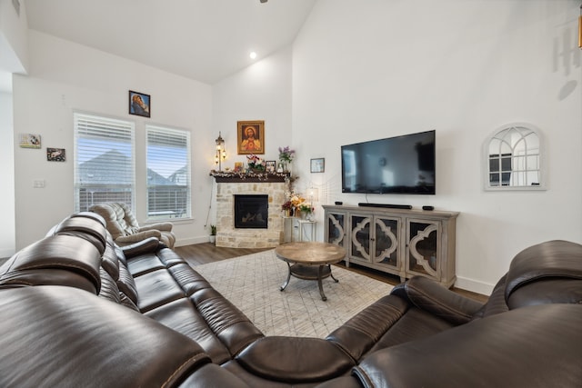 living room with a fireplace, hardwood / wood-style floors, and high vaulted ceiling