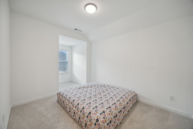 bedroom featuring light carpet and lofted ceiling