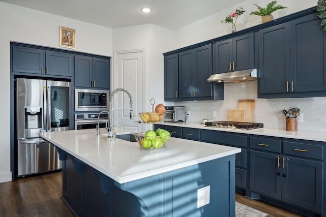 kitchen featuring stainless steel appliances, dark hardwood / wood-style flooring, a kitchen island with sink, and decorative backsplash