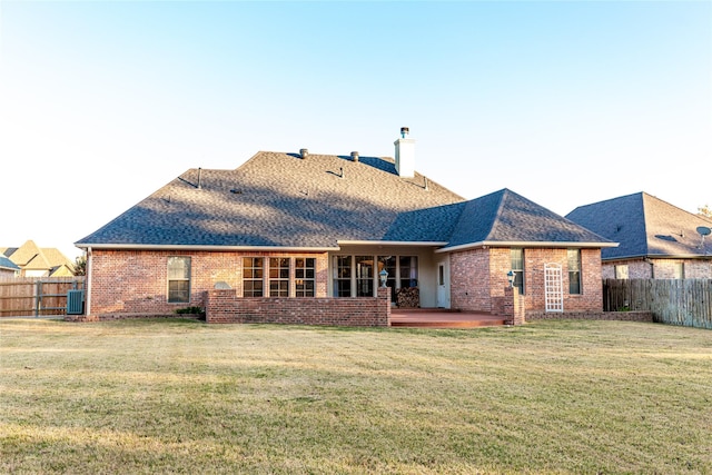 rear view of house with a patio and a lawn