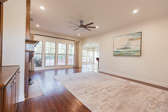 unfurnished living room with dark hardwood / wood-style flooring, ornamental molding, and ceiling fan