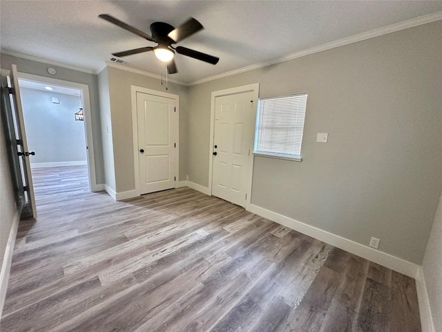 spare room featuring crown molding, ceiling fan, light hardwood / wood-style floors, and a textured ceiling