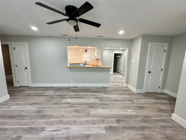 unfurnished living room featuring visible vents, baseboards, a ceiling fan, wood finished floors, and recessed lighting