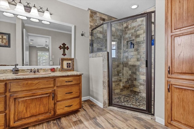 bathroom with hardwood / wood-style floors, vanity, walk in shower, and ornamental molding