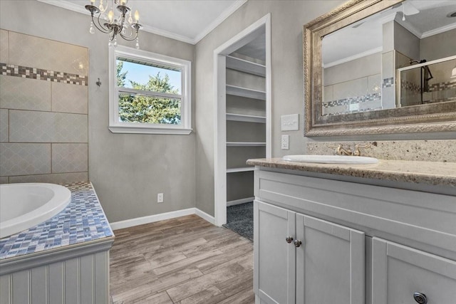 bathroom with crown molding, vanity, wood-type flooring, shower with separate bathtub, and a chandelier