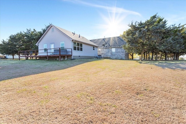 rear view of property featuring a yard and a deck