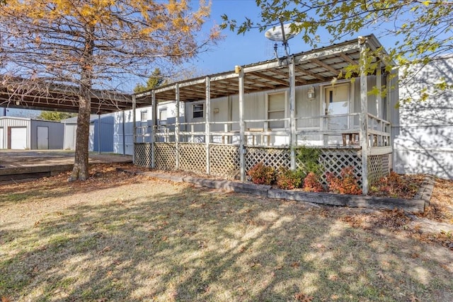 view of side of property with covered porch, an outdoor structure, and a lawn