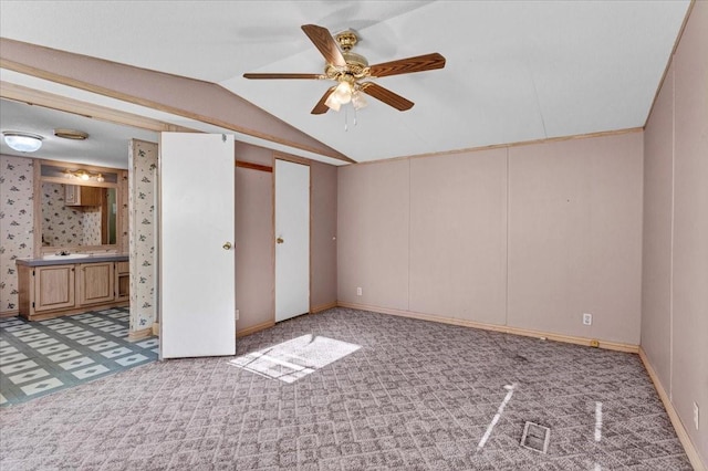 unfurnished bedroom with light carpet, connected bathroom, ceiling fan, and lofted ceiling