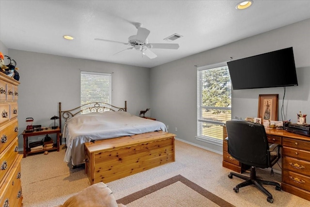 carpeted bedroom featuring multiple windows and ceiling fan