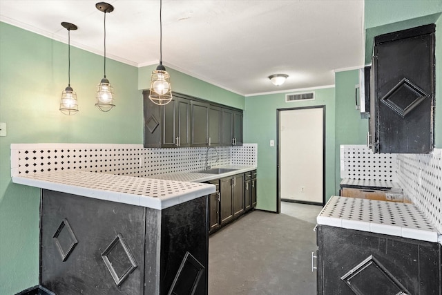 kitchen with pendant lighting, sink, tasteful backsplash, and ornamental molding