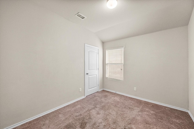 empty room featuring lofted ceiling and carpet