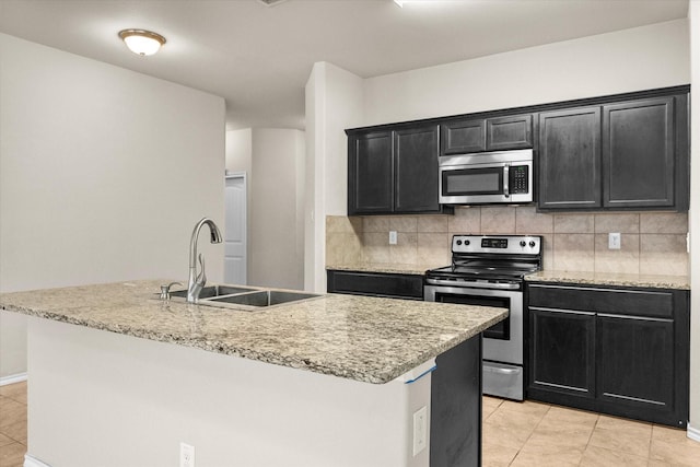 kitchen with tasteful backsplash, appliances with stainless steel finishes, sink, and a kitchen island with sink