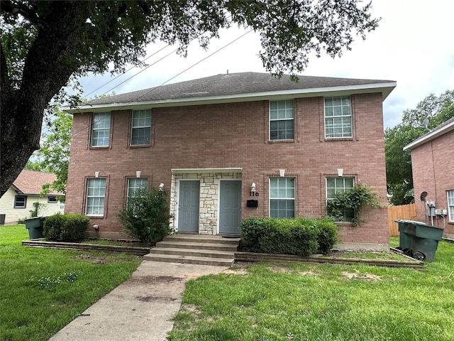 colonial-style house featuring a front lawn