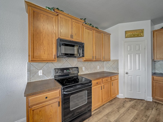 kitchen featuring a textured ceiling, tasteful backsplash, light hardwood / wood-style flooring, and black appliances