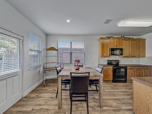 dining space featuring a wealth of natural light and light hardwood / wood-style flooring