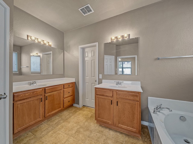 bathroom featuring vanity and a bath