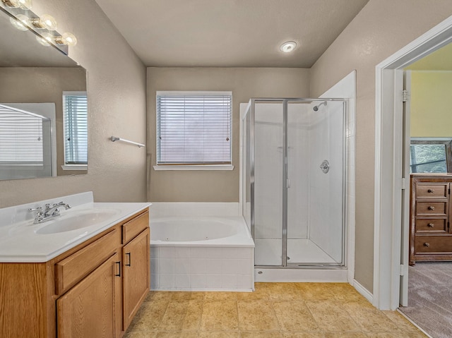 bathroom with plus walk in shower, vanity, and tile patterned flooring