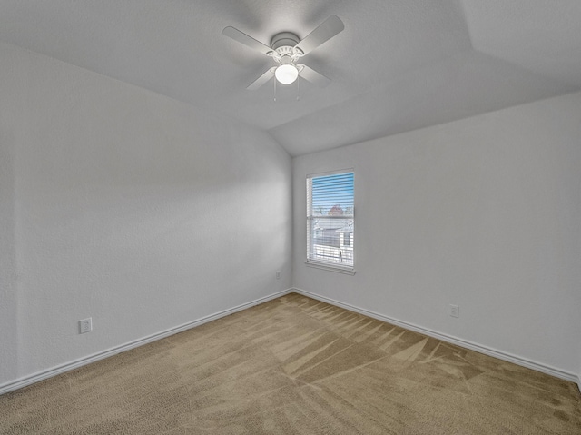 carpeted empty room featuring ceiling fan and lofted ceiling